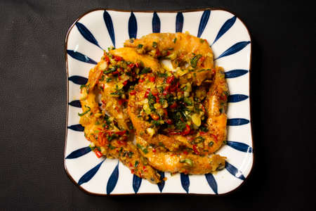 Thai chef cooking food thai style cuisine salad fried roasted shrimp or prawn with chili pepper and salt serve on ceramic dish plate at restaurant cafe shop in Bangkok, Thailandの写真素材