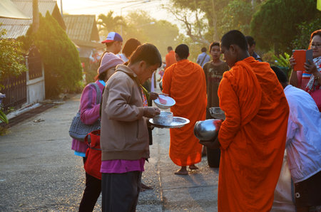 Tradition thai of almsgiving thai monks procession walk on the street for thai people respect...