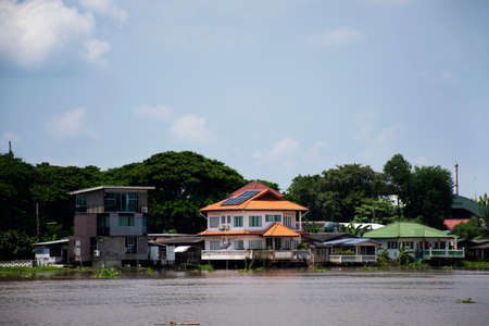 View landscape and chao phraya river with modern luxury house and antique retro vintage home at riverside Pathumthani city and movement water while high north water and flood in Pathum Thani, Thailandのeditorial素材