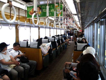 Interior design local train and japanese people and foreign travelers passenger inside use service journey work and travel by railway in Arashiyama station at Kyoto on July 11, 2015 in Kansai, Japanのeditorial素材