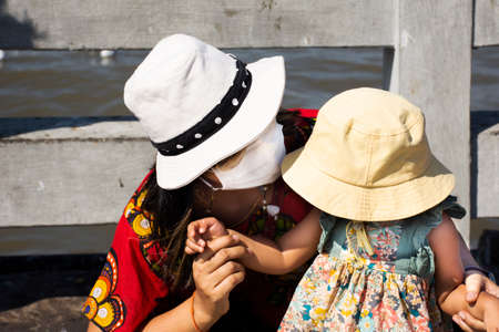 Lifestyle new normal of thai women wear mask and daughter travel visit look regular seasonal migration of seagulls birds at Bangpu Recreation Center while COVID 19 outbreak in Samut Prakan, Thailandの写真素材