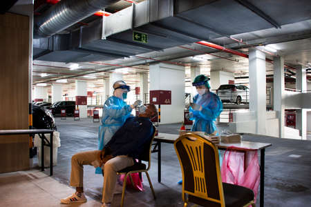 Thai officer operator check test healthy of Coronavirus disease Covid-19 or corona virus covid 19 by testing rapid antigen test kit for travelers guest at hotel on April 25, 2022 in Bangkok, Thailandのeditorial素材