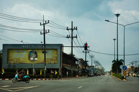 Traffic light intersection with thai people and foreign travelers riding motorcycle and driving vehicle car and biking bicycle on street in Pak Bara at La ngu city on April 12, 2022 in Satun, Thailandのeditorial素材