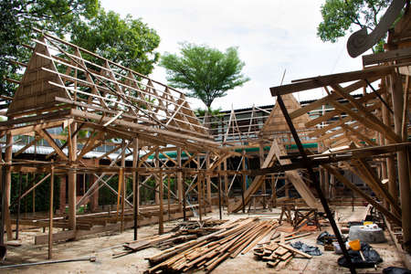 Thai professional carpenter people working and use teak build structure woodwork new building wooden church pavilion in construction site at Wat Sangkhatan temple in Bang Pai of Nonthaburi, Thailandの写真素材