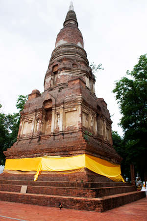 Ancient stupa or antique chedi and ruins buddha and ubosot for thai people traveler travel visit and respect praying blessing holy mystery of Wat Phra Kaew temple at Chainat city in Chai Nat, Thailandの写真素材