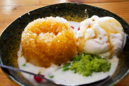 Local traditional thai dessert sweet meal and snack shaved ice with coconut ice cream on ceramic bowl serve for thai people customer eat drink on table at restaurant cafe shop in Chiang Rai, Thailandの写真素材