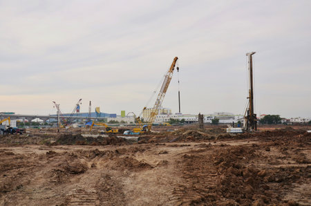 Asian labor people and thai labour worker use machine and heavy machinery working builder railway track electric sky train at construction site building on scaffold at capital city in Bangkok Thailandの写真素材