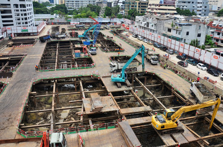 Asian labor people and thai labour worker use machine and heavy machinery working builder railway track electric sky train at construction site building on scaffold at capital city in Bangkok Thailandの写真素材