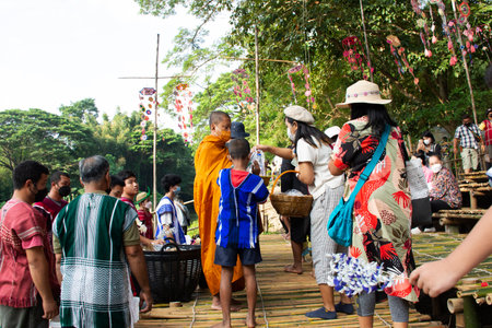 Thai people foreign travelers travel visit and join tradition merit ritual praying and offerings almsgiving of oh poi local market bazaar at Suan Phueng city on November 5, 2022 in Ratchaburi Thailandのeditorial素材