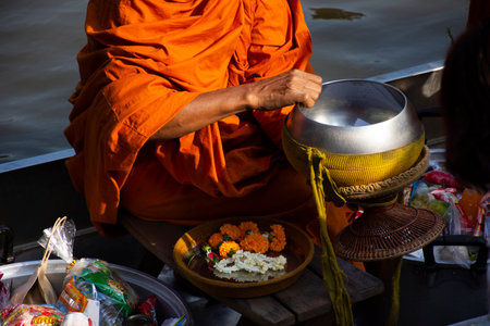 Thai people foreign traveler travel visit and join tradition merit ritual and praying offering alms giving to monk procession on boat in canal at Wat Sai Yai on November 8, 2022 in Nonthaburi Thailandのeditorial素材