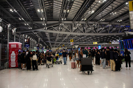 Thai people and foreign travelers passengers walking carry luggage baggage in terminal for check in travel visit journey at Suvarnabhumi International Airport on February 16, 2023 in Bangkok, Thailandのeditorial素材