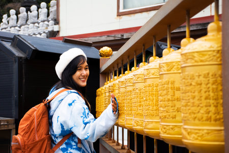 Traveler thai women travel visit and rite rotate spin with prayer wheels for praying blessing holy...