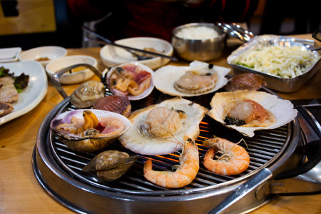Gourmet food grilled roasted seafood and shell fried burn for korean people traveler travel visit and taste eat drinks cuisine in local restaurant at Hueundae Street Foodâ Market in Busan, South Koreaの写真素材