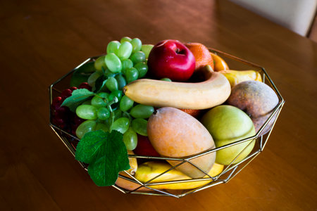 Variety fruits in aluminum basket on wooden table in dining room of restaurant cafe coffee shop for thai people and travelers customer use service at Nakhon Pathom, Thailandの写真素材
