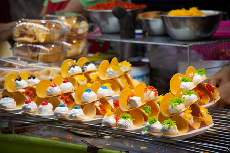 Traditional local thai dessert Khanom bueang crispy pancakes or thai crepes snack with variety toppings for people traveler eat in street market bazaar temple annual festival in Nonthaburi, Thailandの写真素材