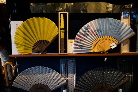 Vintage souvenirs silk hand fan or retro handmade fabric handheld folding Fan with drawing painting in gift shop for japanese people travelers select buy at Narita city on July 7, 2024 in Tokyo, Japanのeditorial素材