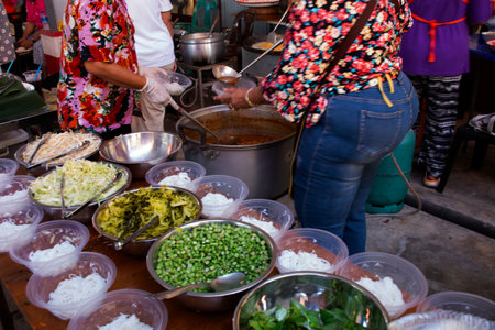 Traditional thai food Khanom jeen or noodles rice vermicelli with fish curry sauce with vegetable in almshouse for served guest join Kathina ceremony at Wat Bang Rak Yai temple in Nonthaburi, Thailandの写真素材