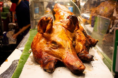 Traditional wisdom and local popular dish Trang roasted pork or grilled pig crispy skin with dipping soy sauce for thai people travelers buy eat drinks at local street food market in Bangkok, Thailandの写真素材