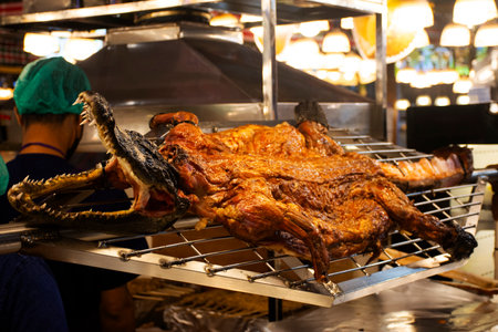 Exotic food and new strange taste cuisine grilled crocodile meat or roasted BBQ alligator with dipping sauce for thai people travelers buy eat drinks at local street food market in Bangkok, Thailandの写真素材
