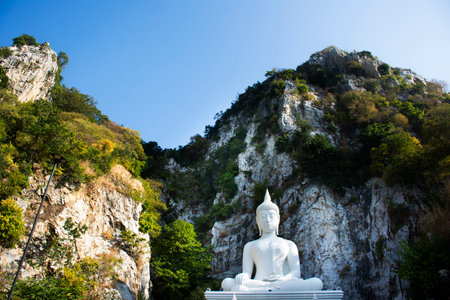 White holy buddha ancient statue on mountain in forest for thai people travelers travel visit respect blessing wish mystery at Wat Khao Wong Narai Cave Temple in Phra Phutthabat of Saraburi, Thailandの写真素材