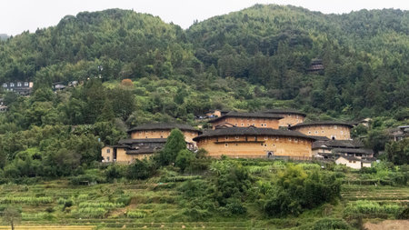View landscape of Nanjing Terraced rice fields farming and Nanjing Tulou Hakka Houses earth building on mountain for chinese people travelers travel visit in Shuyang town of Zhangzhou in Fujian, Chinaの写真素材