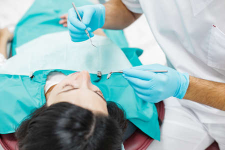 Cute young girl is being examined by the dentist