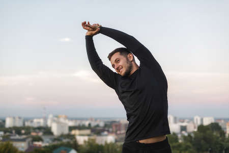 Image of healthy man stretching his body at sports ground outdoorsの写真素材