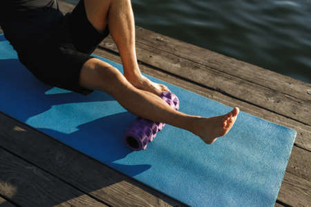 Image of healthy man stretching his body at sports ground outdoors