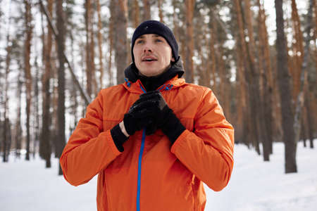 Portrait of a man stretching in the park on a beautiful snowy winter day