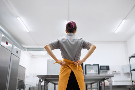 A bright young pastry chef girl puts on a work uniformの写真素材