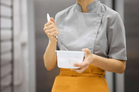 A bright girl cooks sweet dishes at a small production facility