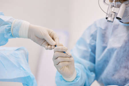 The doctor holds a medical instrument in his handsの写真素材