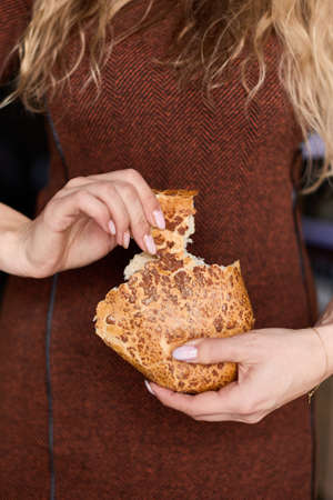 Womens hands break off a piece of fresh bread, close upの写真素材