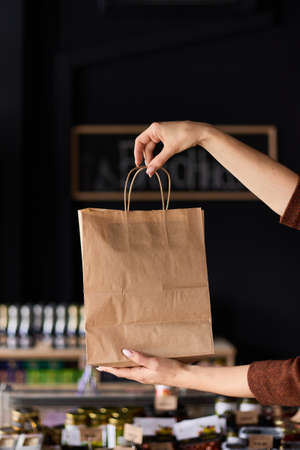 The girl holds a paper bag in her handsの写真素材