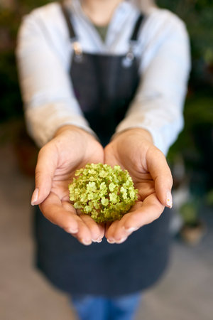 Close-up of young woman holding green flower