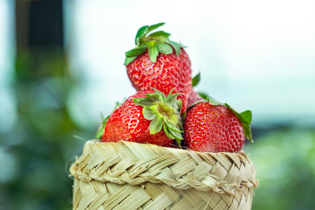 Strawberry in a basket on green nature background. Fresh strawberries.の写真素材