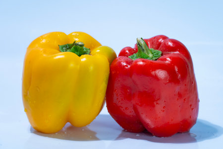 Red and yellow bell pepper on a blue background. Vegetables.の写真素材