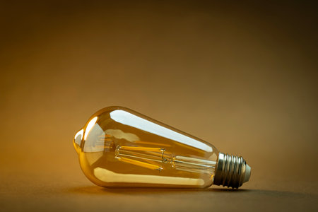 Yellow light bulb on brown background with copy space for your text.の写真素材