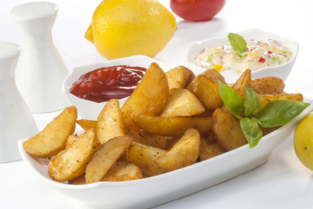 Fried potato wedges with coleslaw & ketchup with basil leafの写真素材
