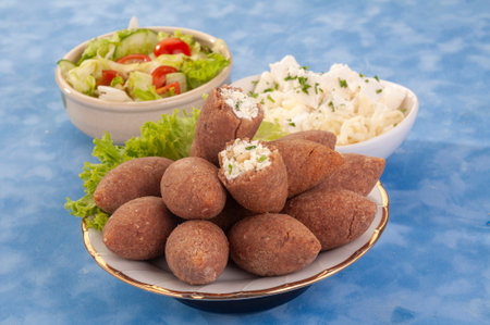 Fried Lamb Kibbe with salad and mayonnaise on blue backgroundの写真素材