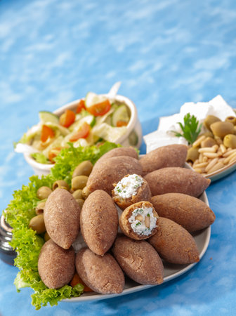 Salad with Fried Lamb Kibbe and cheese on a blue background.