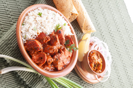 Indian chicken tikka masala served with rice and naan breadの写真素材