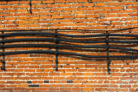 Communication: cable and wire-hanging on a brick wall.の写真素材
