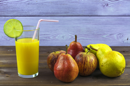 A glass of freshly squeezed orange juice, pears and applesの写真素材