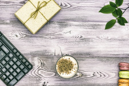 Mug with yogurt, gift wrapped in paper and biscuits macaroons.の写真素材