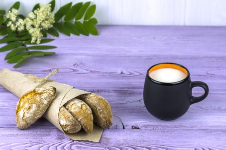 On the table, spring flowers, a mug of milk and sweet homemade cookies.の写真素材