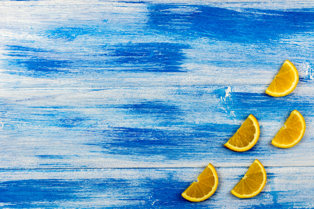 Orange slices on a blue background. Wood textureの写真素材