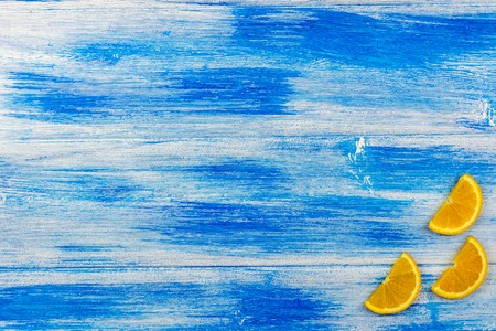 Orange slices on a blue background. Wood texture