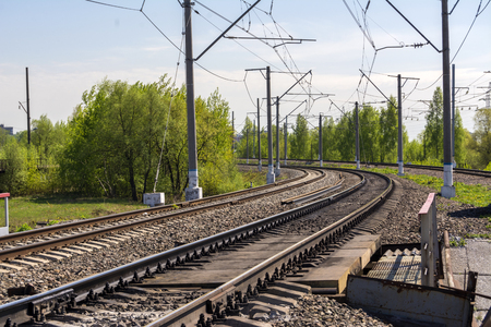 A sharp turn of the Railway. Three ways. Poles with electrical wire. Summerの写真素材