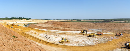 Panorama of the quarry. Extraction of sand in the quarry. Backhoe loading sand into dump trucks.